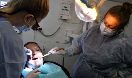 Dr. Ashley Orth, dental resident, and Nohora Hernandez, dental assistant examine Jose Rodriguez, Jr.