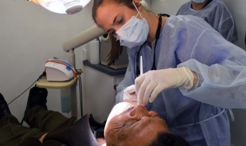 Jose Amparan grimaces as Dr. Rachel Embree, dental resident, numbs his mouth.